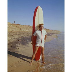 Surfer holding Surfboard on Beach