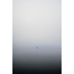 SUP Stand up paddling on mountain lake in early morning